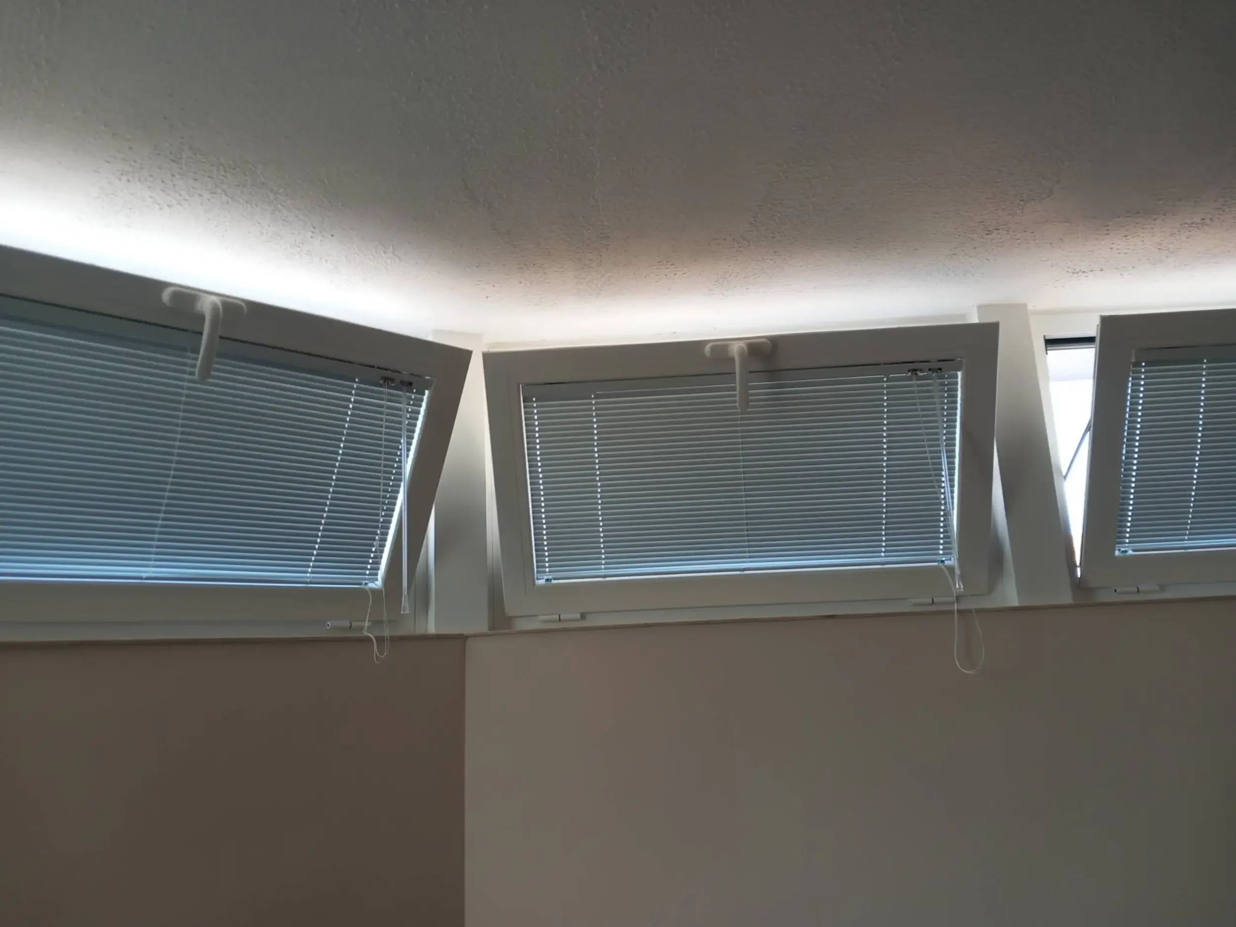 Oscuramento: Tende veneziane chiuse su installazione multipla di finestre.