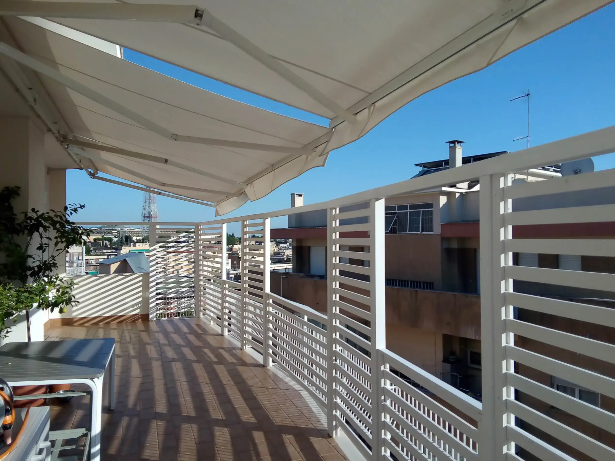 Installazione: Tende a bracci motorizzate bianche Tempotest su un balcone romano.
