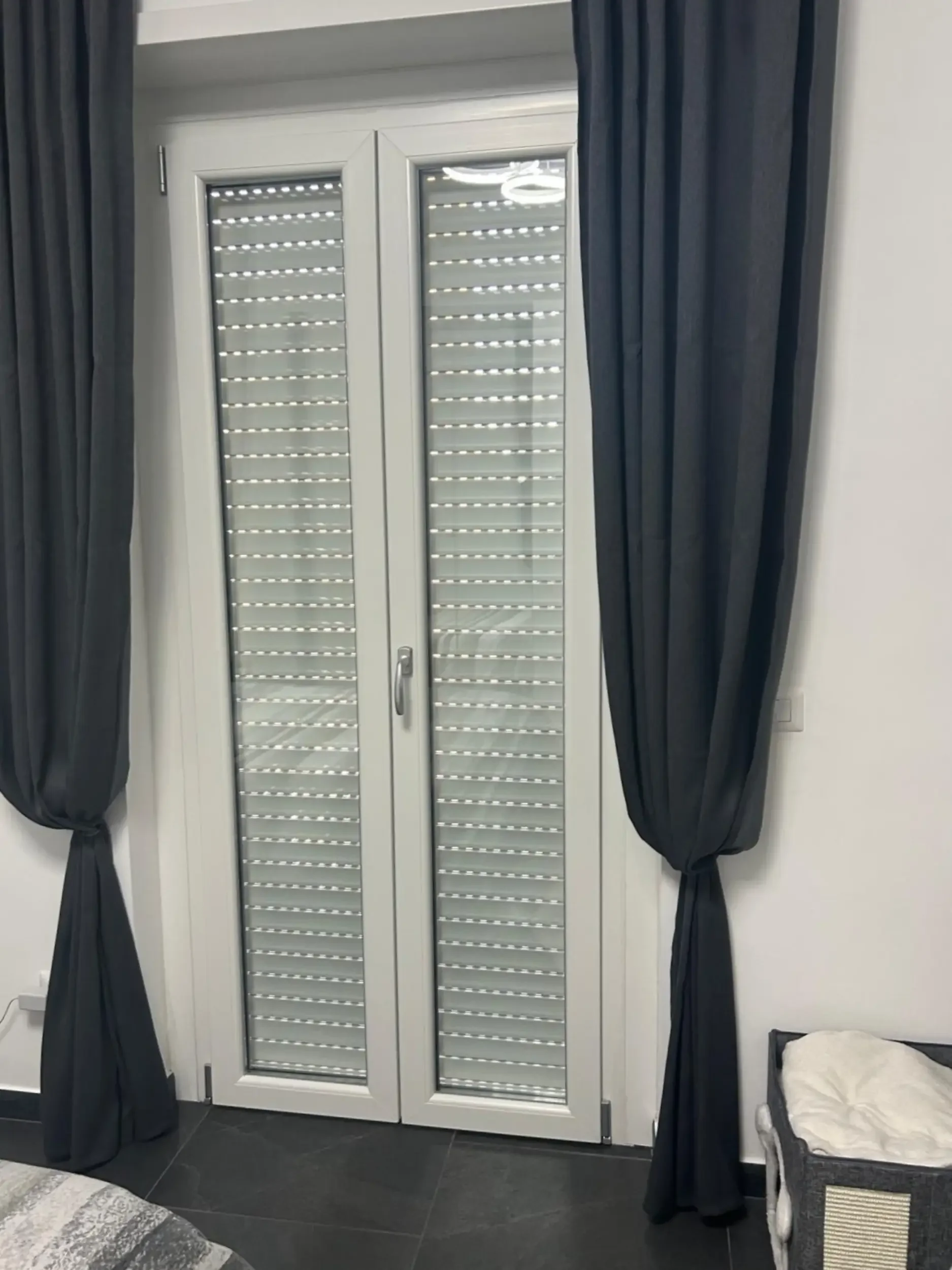 Interni: Porta soggiorno protetta da moderni avvolgibili in alluminio.