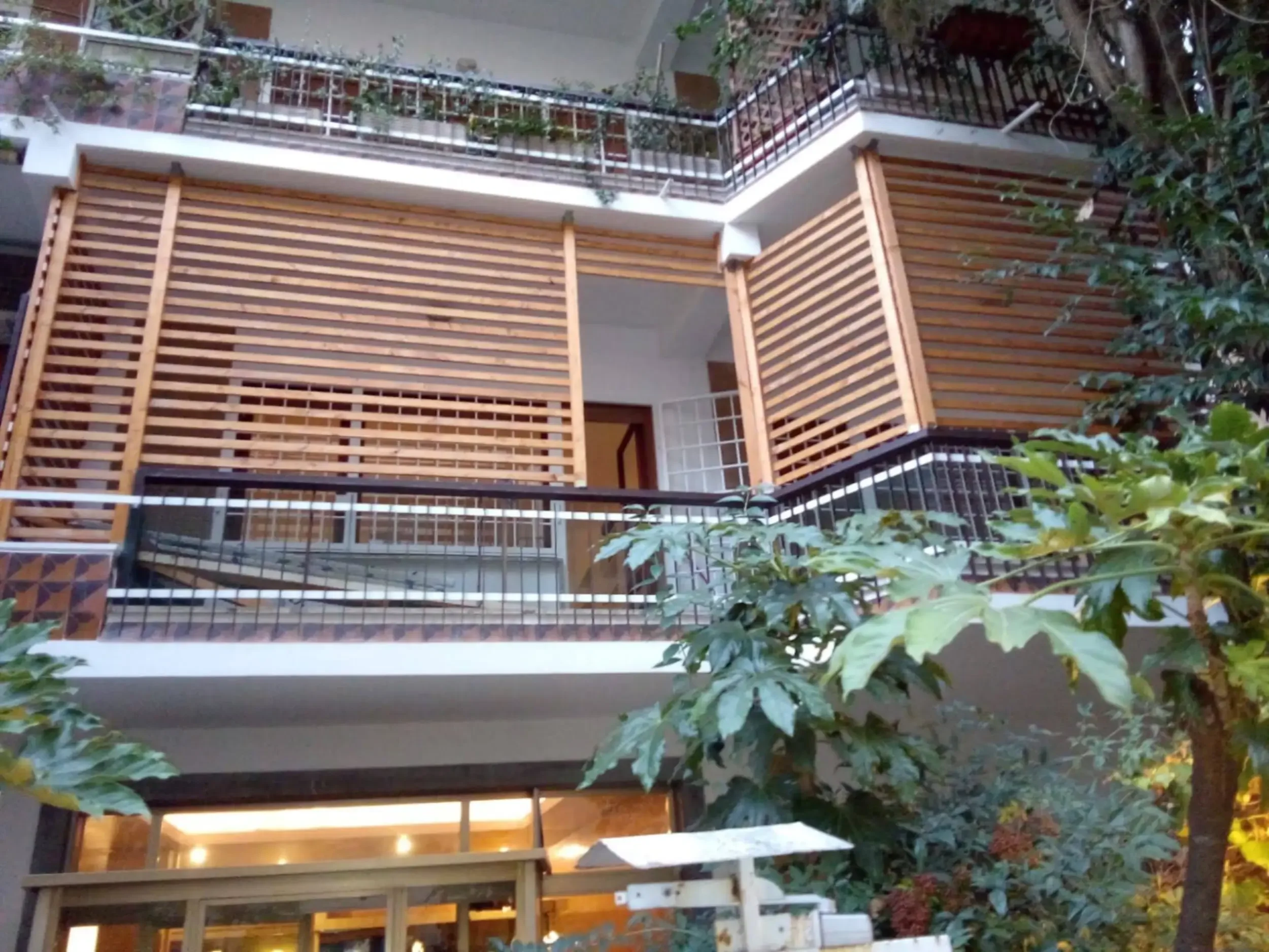 Design: Terrazzo completamente recintato con pannelli grigliati orizzontali in legno rustico.