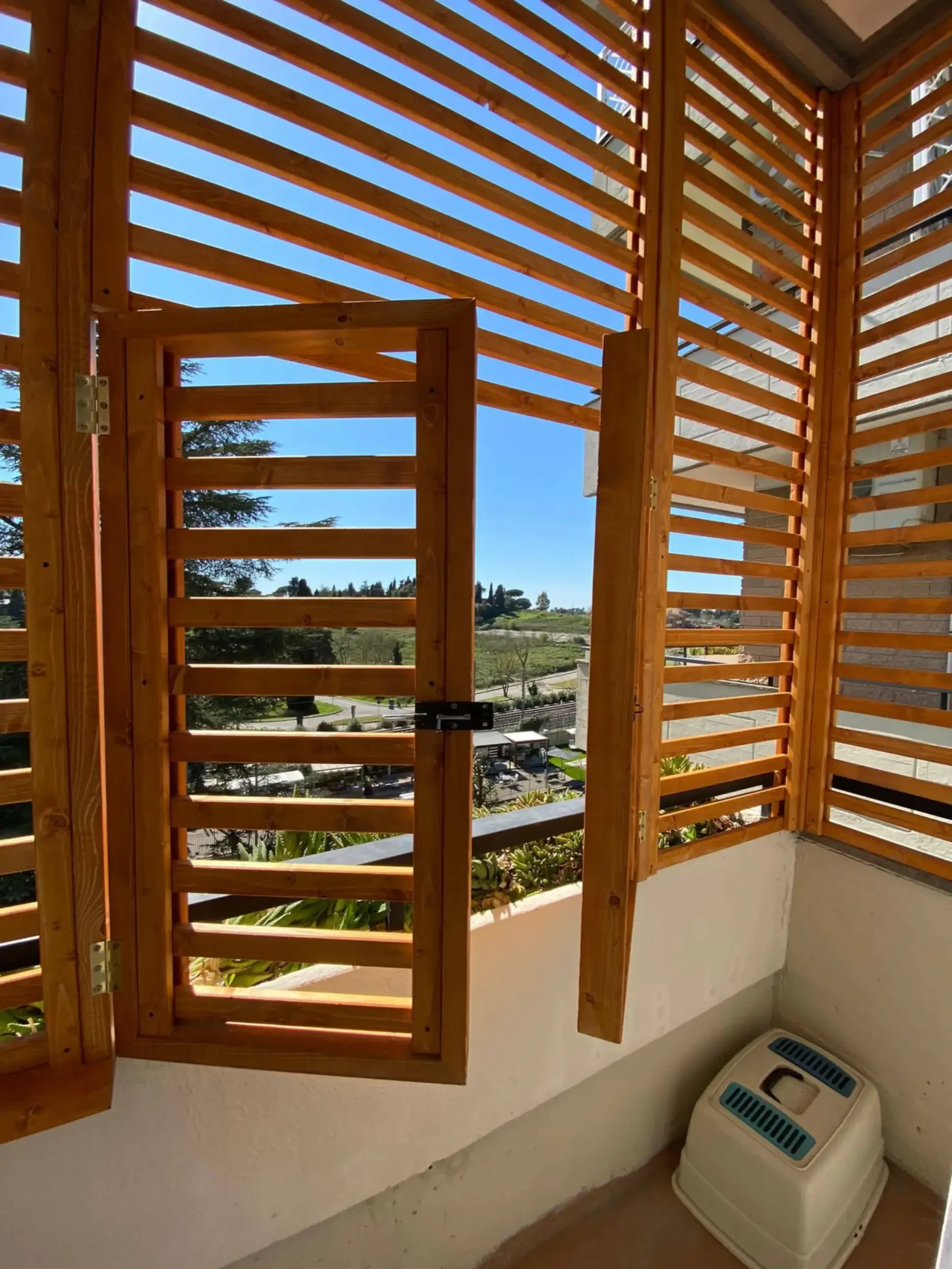 Stile: Pannelli in griglia di legno su un balcone per un aspetto rustico a Roma.