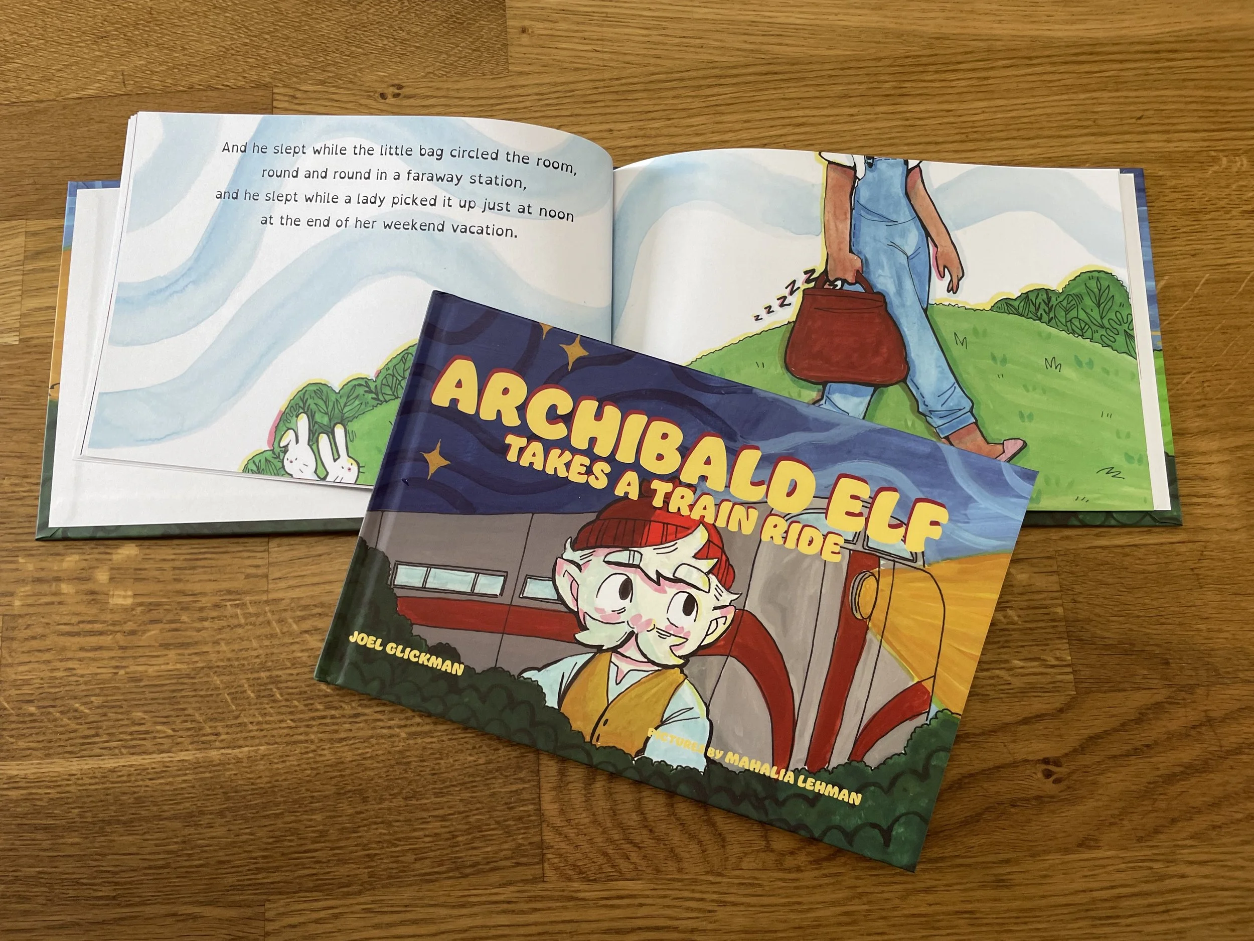 Open children's book on a wooden surface showing colorful illustrations and text.