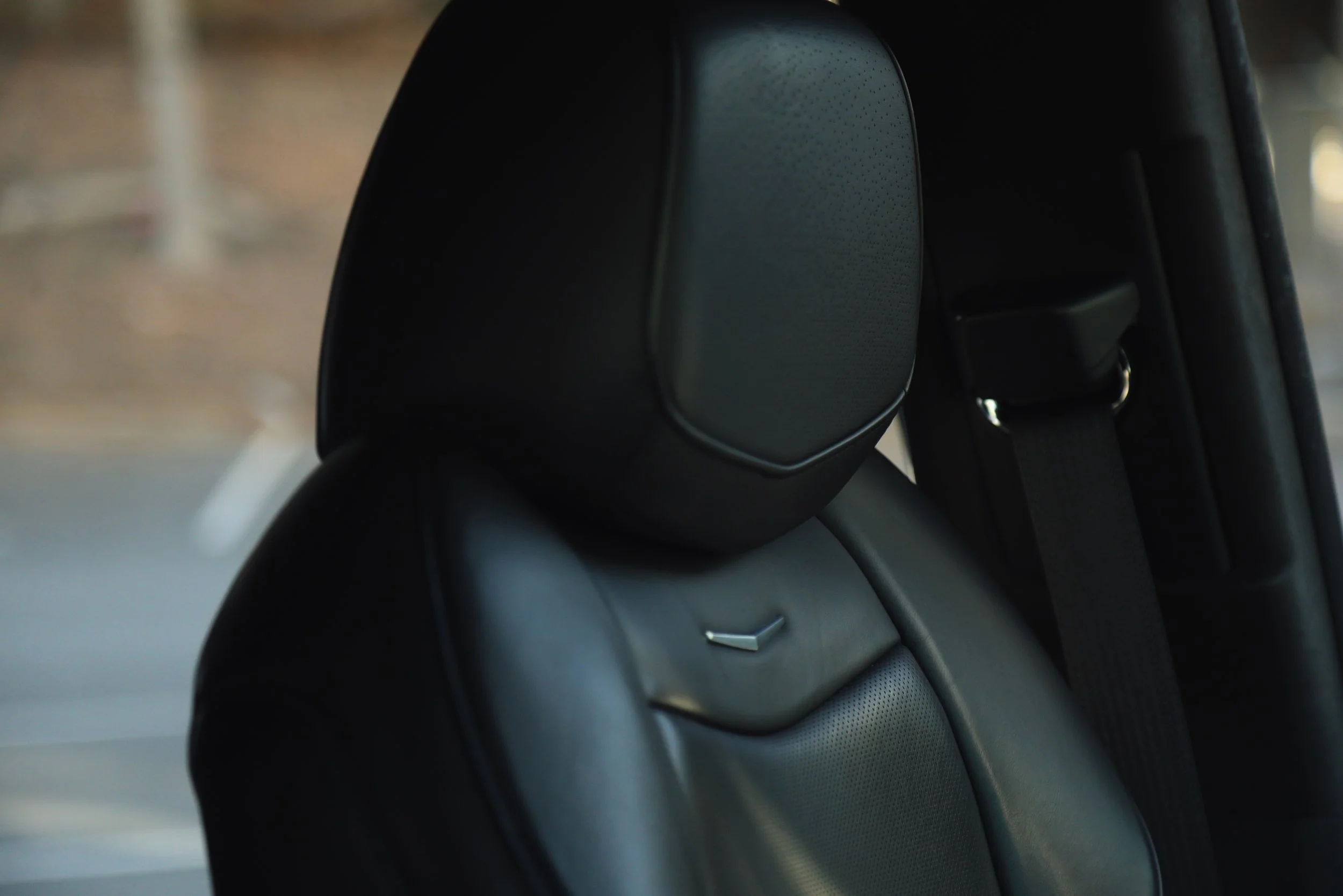 Close-up of a car's headrest and seat belt in the interior.