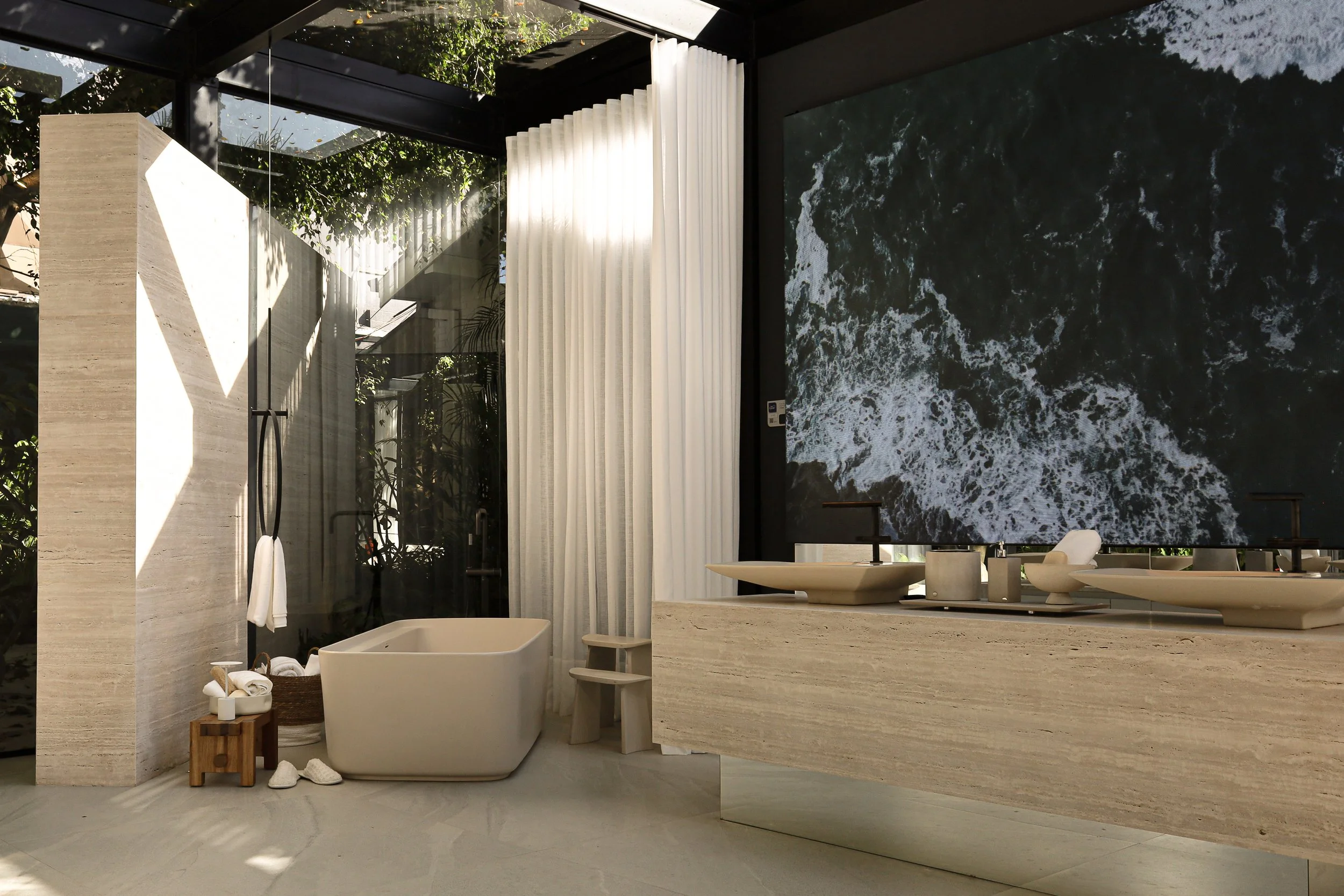 Banheiro moderno com banheira, pia dupla e adorno de parede com o mar