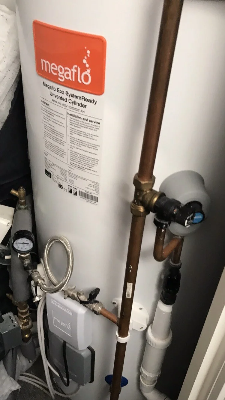 An unvented hot water heater with plumbing and control components visible.