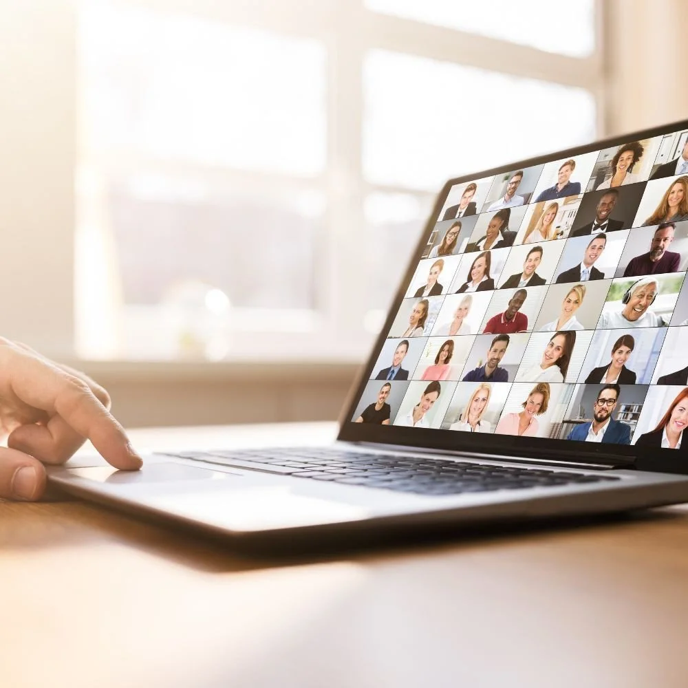 Laptop screen displaying a video conference with multiple diverse people.