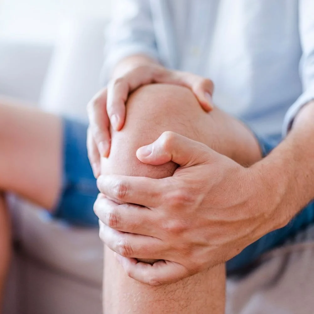 Person holding and examining a knee.