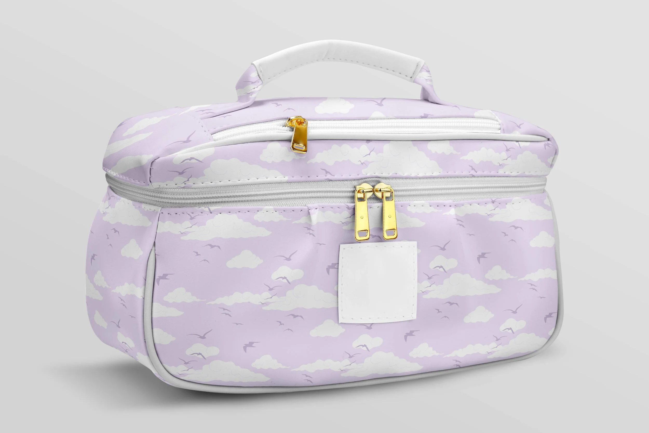 A purple and white backpack with cloud and bird pattern, gold zipper pulls, white handle on top, and front pocket with white tag, against a light gray background.
