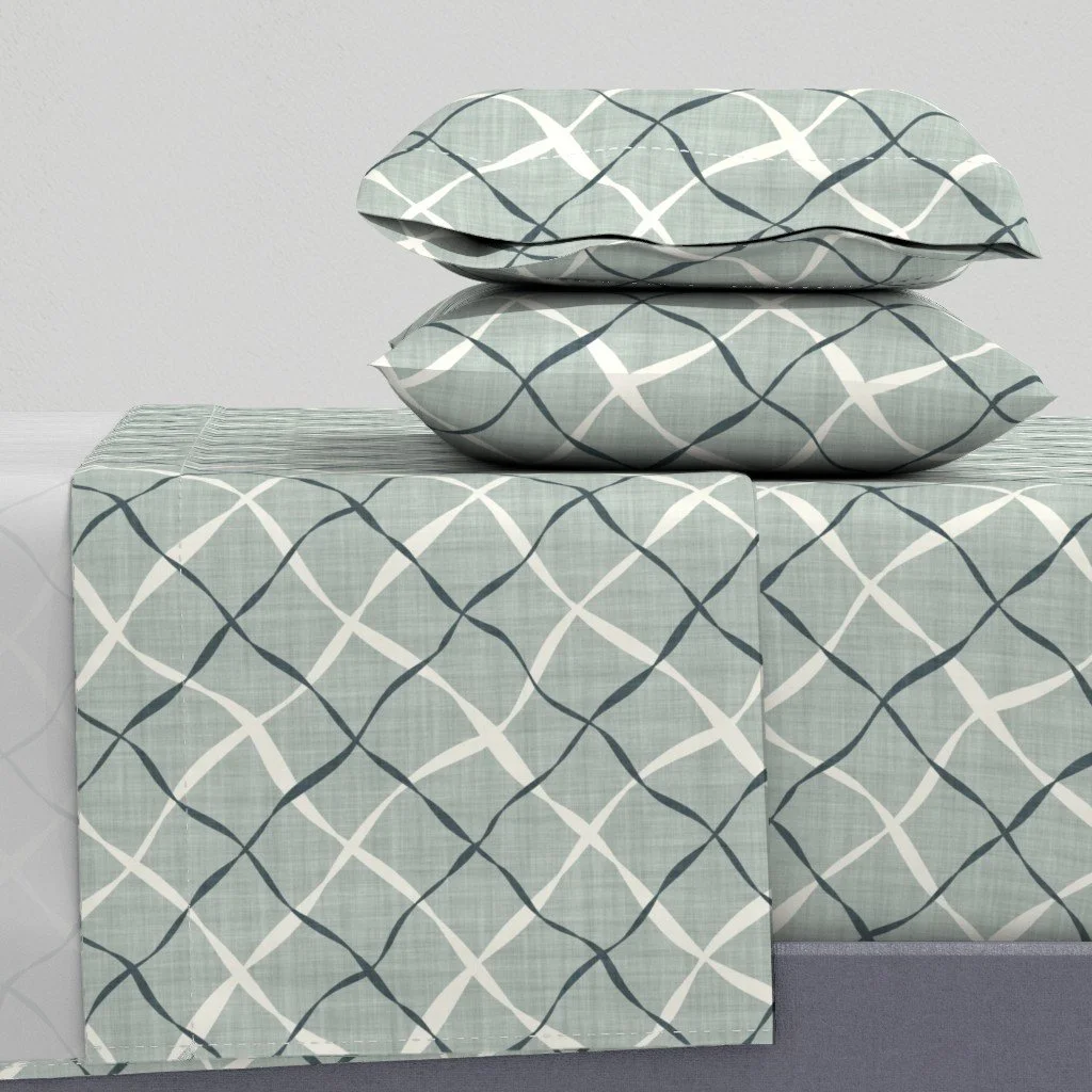Ribbon Lattice by Aitch Jay Designs — muted green‑grey bedding with a refined geometric lattice repeat, offering a calm, contemporary pattern for modern bedroom interiors.