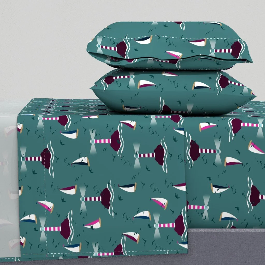 Sail Away Storybook Collection by Aitch Jay Designs — teal lighthouse and sailboat repeat with coastal waves, shown on bedding to create a playful nautical, ocean‑themed bedroom.
