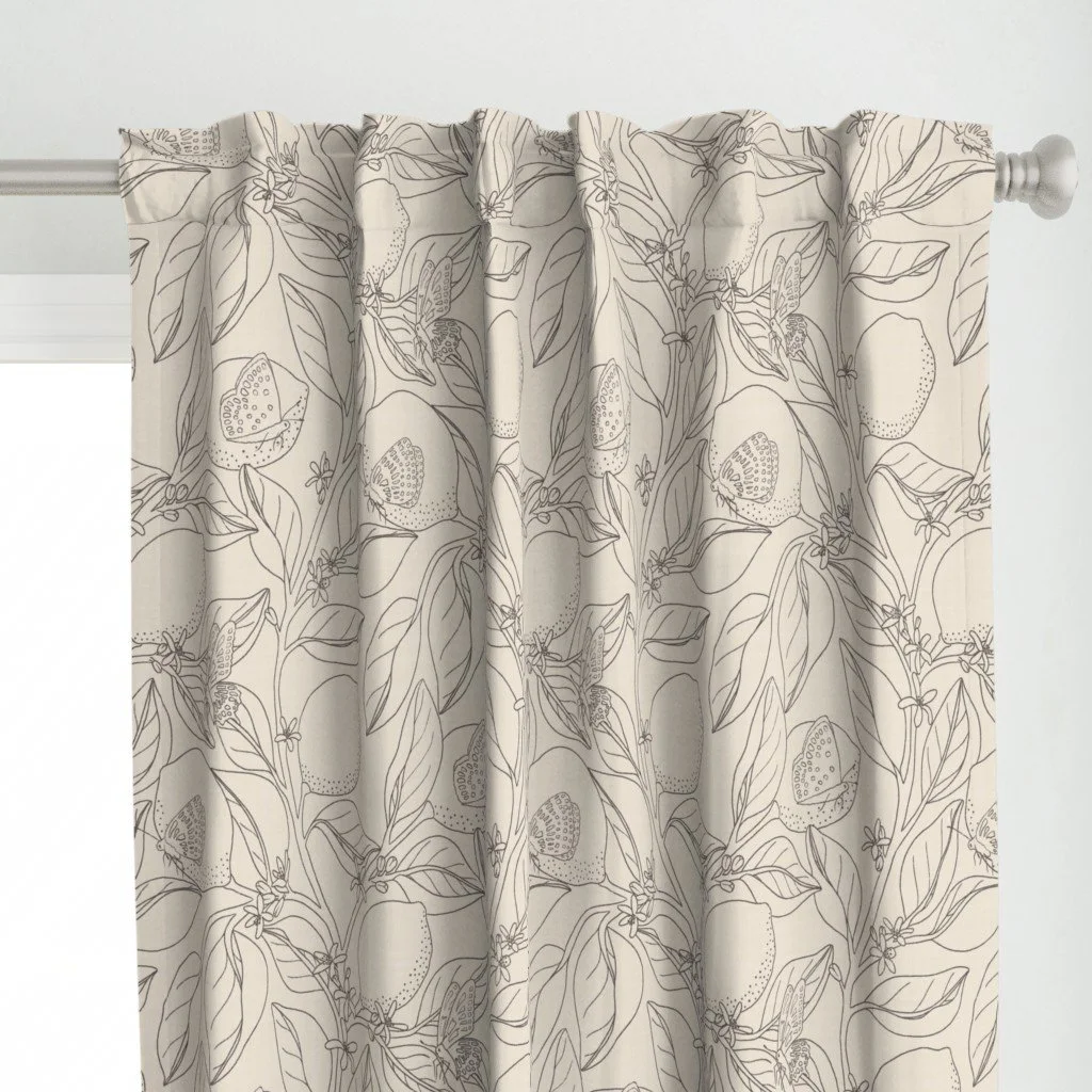 A beige curtain with a butterfly and floral pattern hanging on a curtain rod.