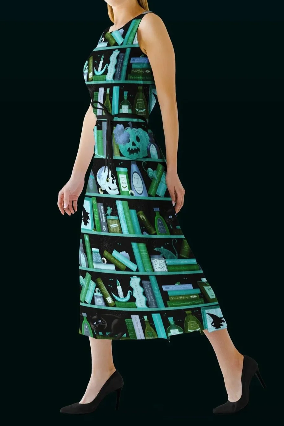 A woman wearing a dress designed to look like a bookshelf filled with books, bottles, and Halloween-themed decorations, paired with black high heels.