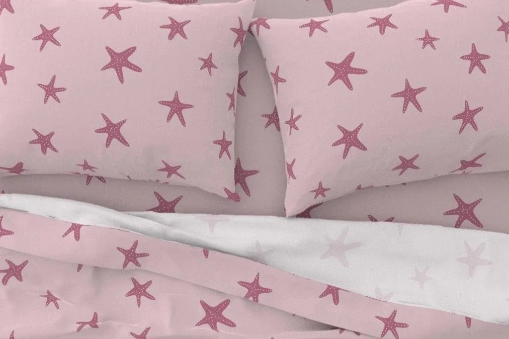 Pink and white starfish-patterned bedding, including pillowcases and sheets.