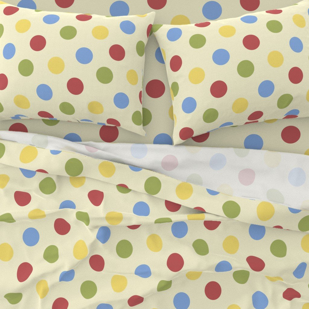 Patterned bed sheets and pillows with polka dots in red, yellow, green, and blue on a light background.