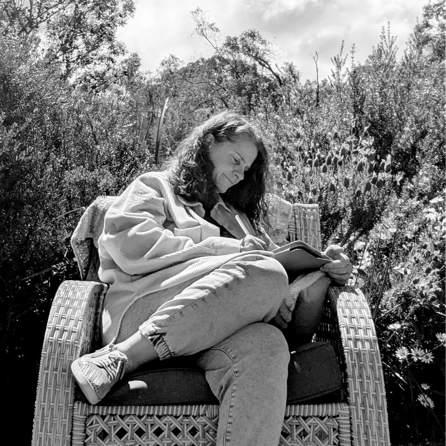 The artist drawing on her tablet in the garden.