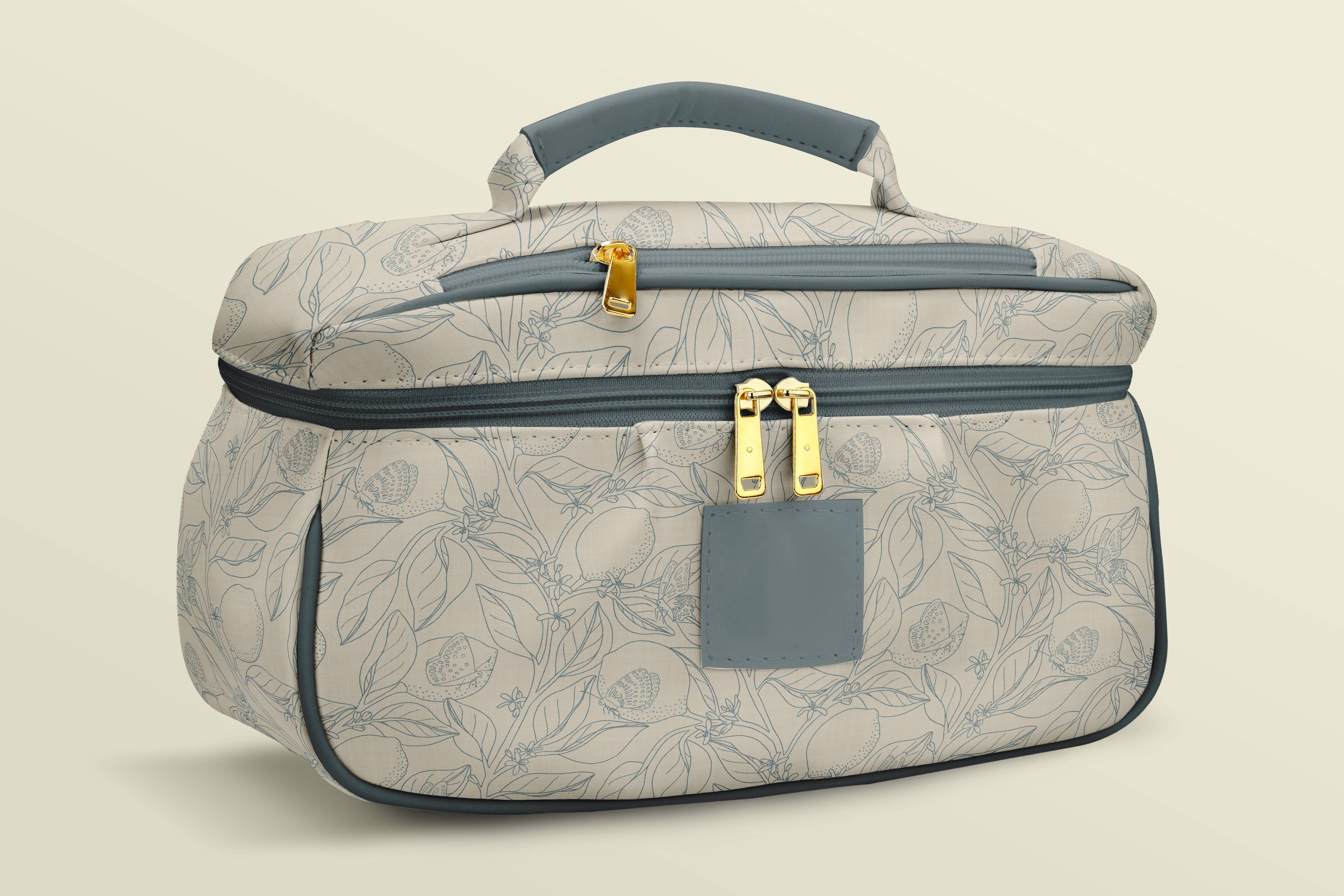 A light-colored duffel bag with a floral and butterfly pattern, featuring grey zipper accents and gold hardware, against a plain beige background.