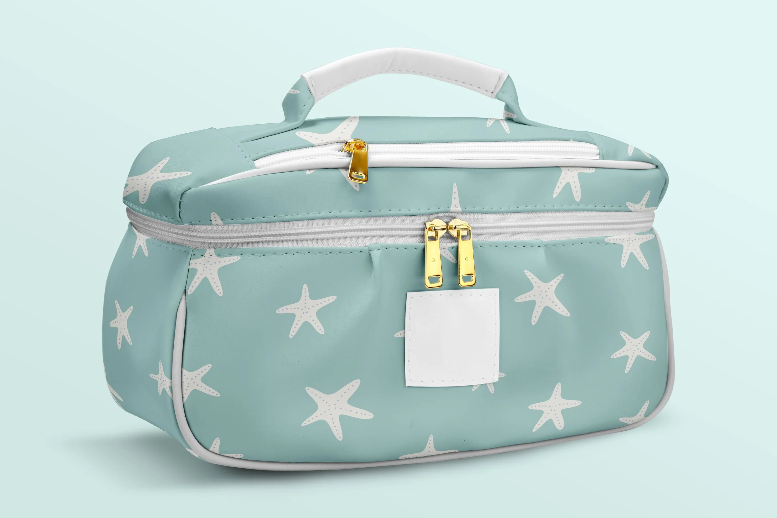 A light blue bag with starfish patterns, featuring gold zippers and a white handle, against a matching light blue background.