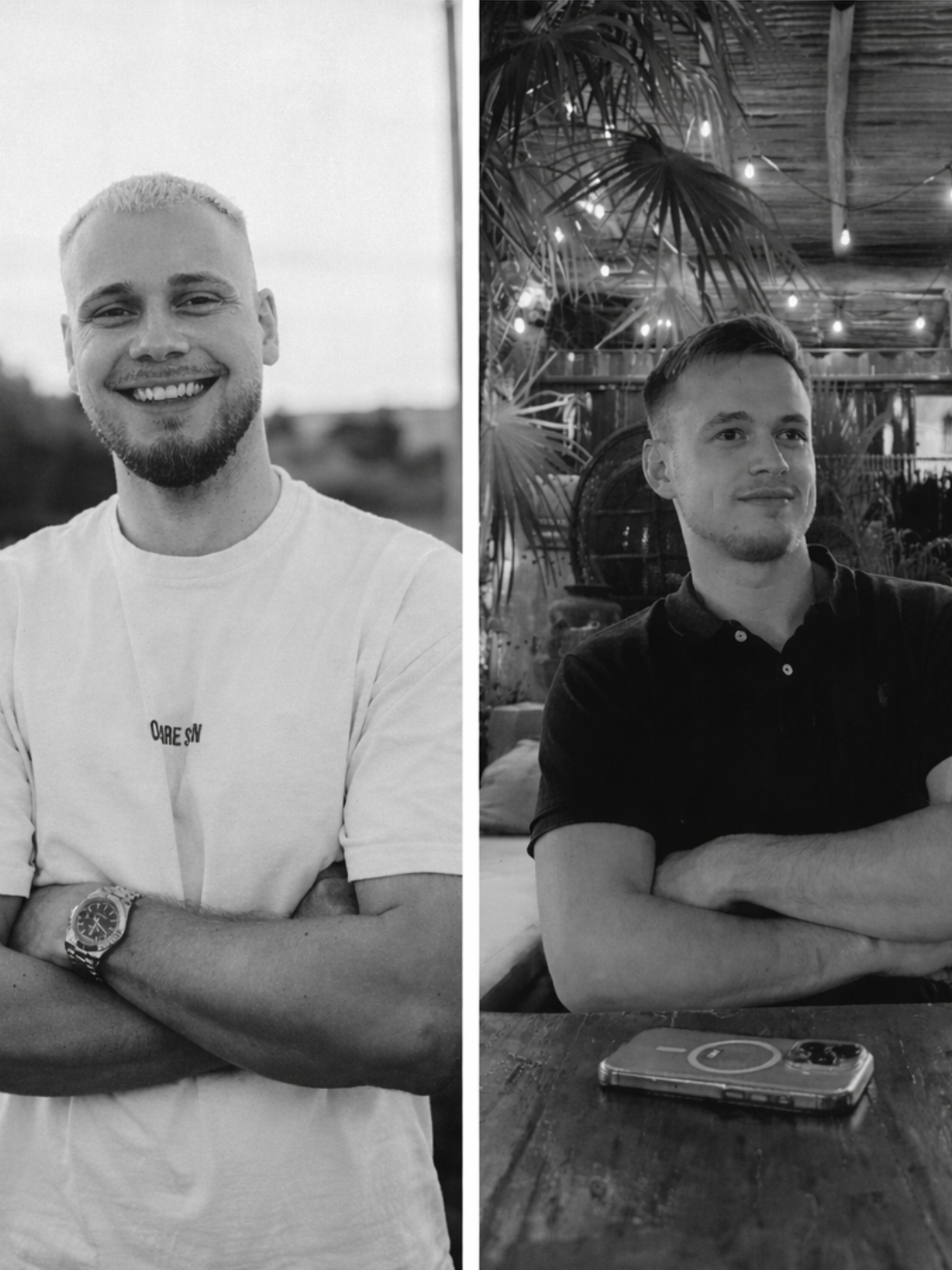 Zwei junge Männer, einer lächelnd mit verschränkten Armen in T-Shirt, der andere sitzend mit verschränkten Armen in Schwarz-Kleid, im Hintergrund eine tropisch gestaltete Inneneinrichtung mit Pflanzen und Lichterketten, beide in Schwarzweiß.