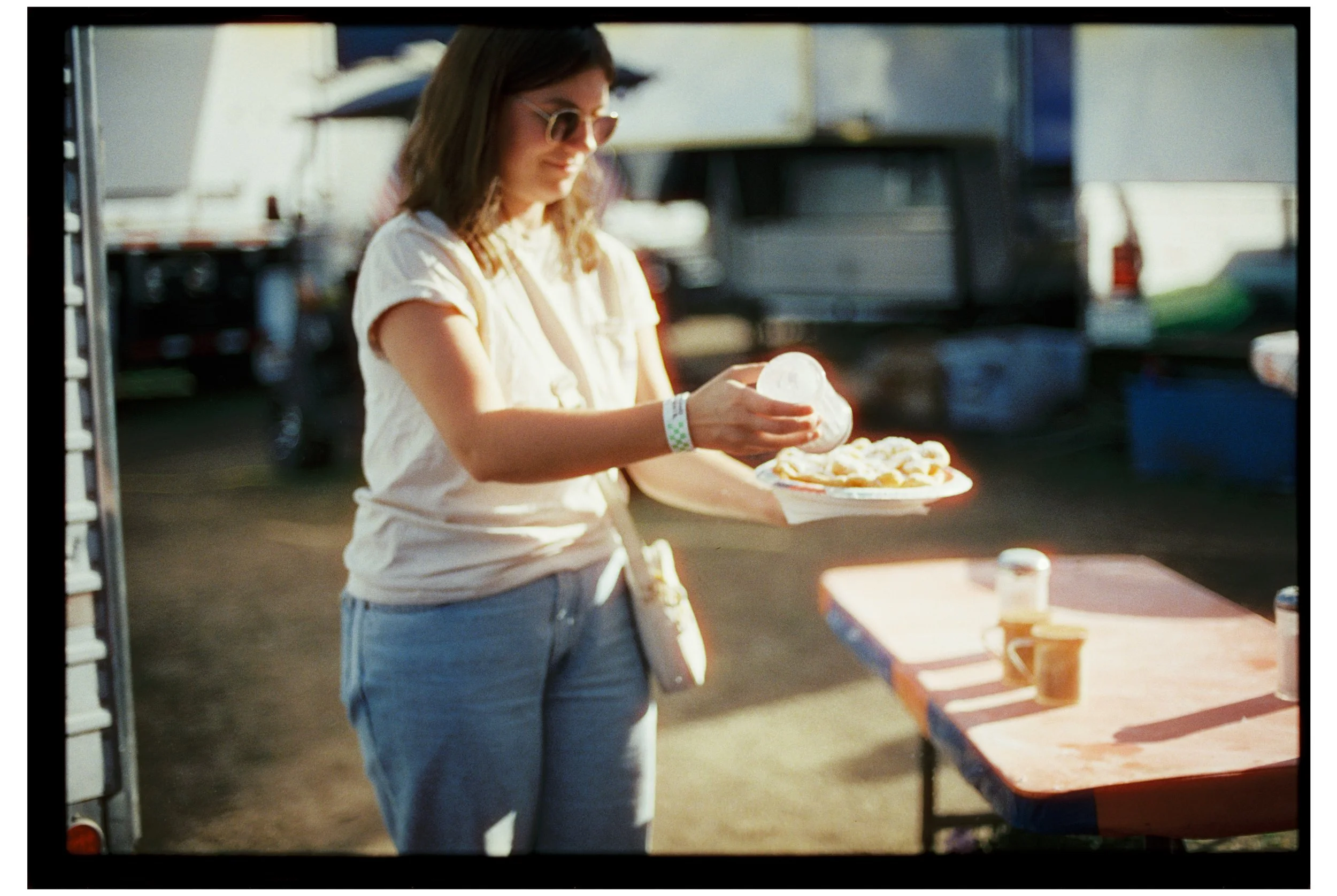 Fryeburg Fair. Becca adds powdered sugar to her funnel cake. Fryeburg, Maine. October 2025. Nikon F3. CineStill 400D.
