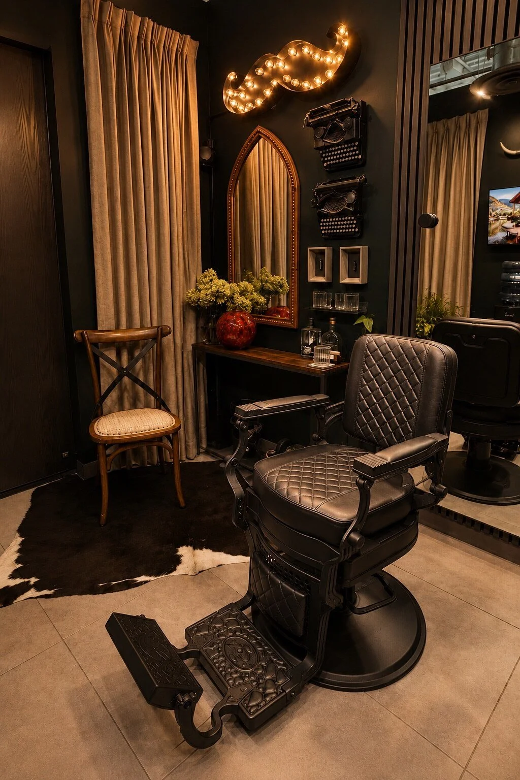Quilted barber chair beneath the illuminated mustache inside the private studio.