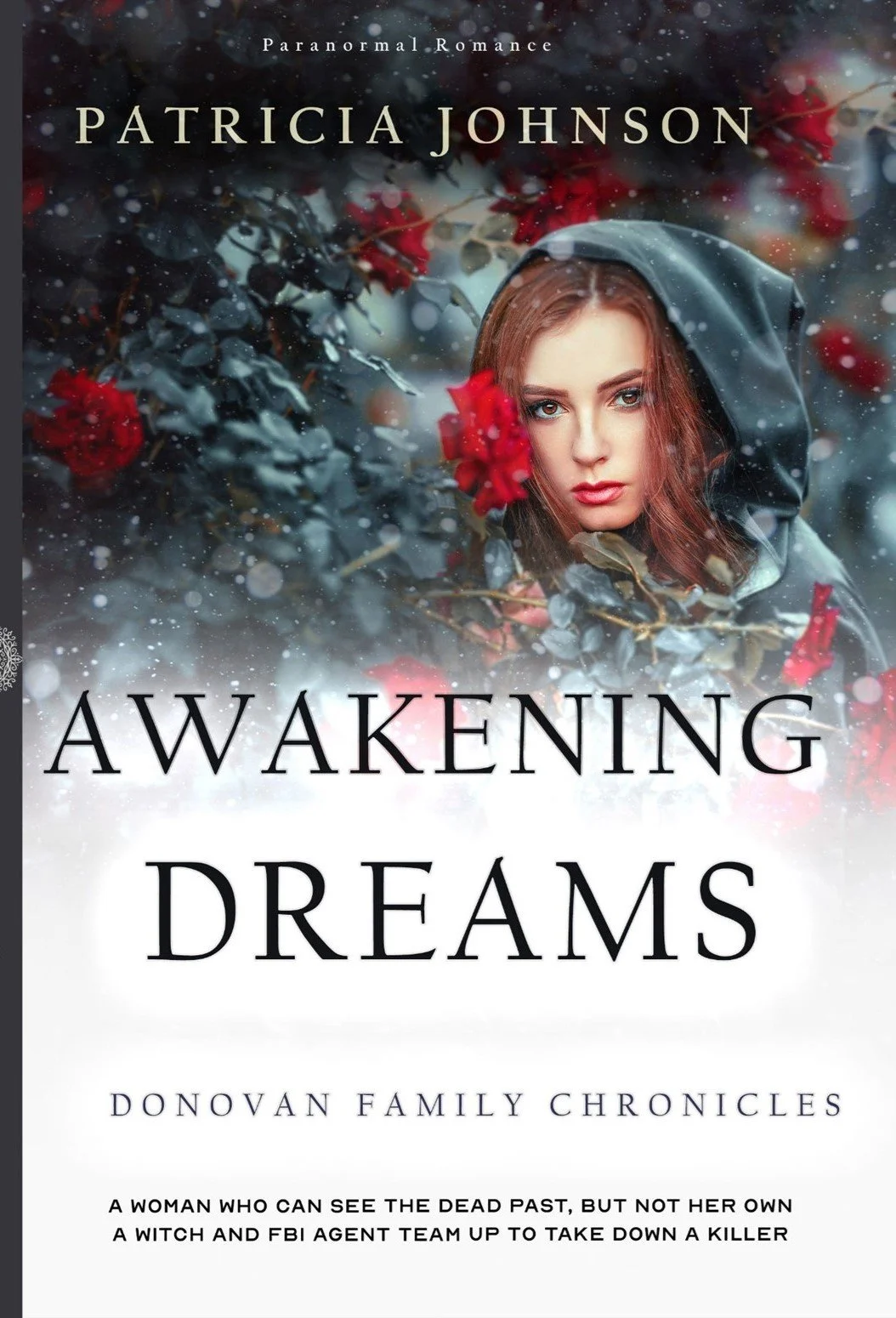 Book cover titled 'Awakening Dreams' by Patricia Johnson, featuring a woman with red hair and blue eyes, wearing a black hood, surrounded by red flowers and snow, with a dark, blurred background.
