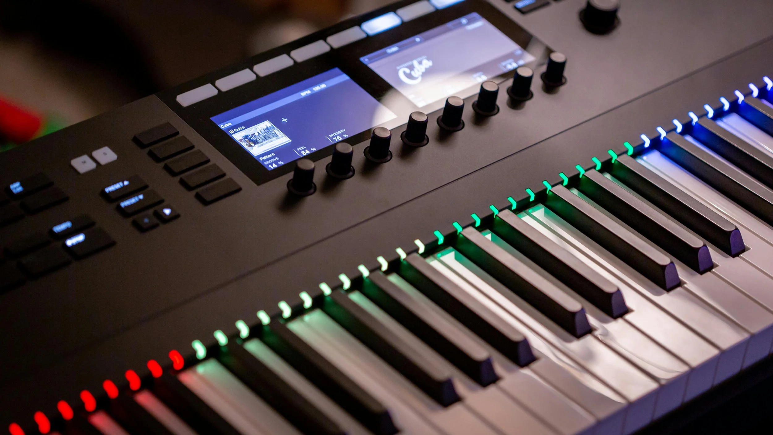 Close-up of a digital music keyboard with illuminated keys and a touchscreen display.