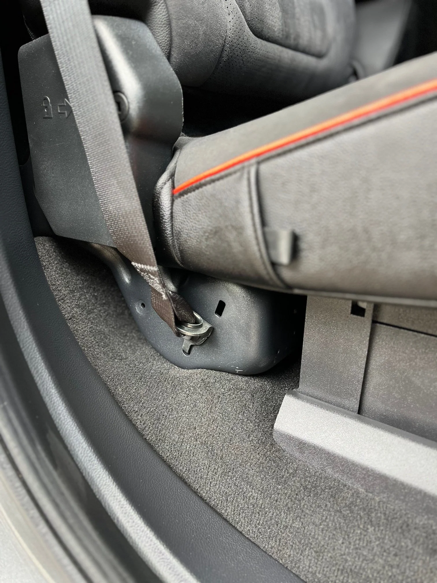 Close-up of the side of a car seat secured with a seatbelt.