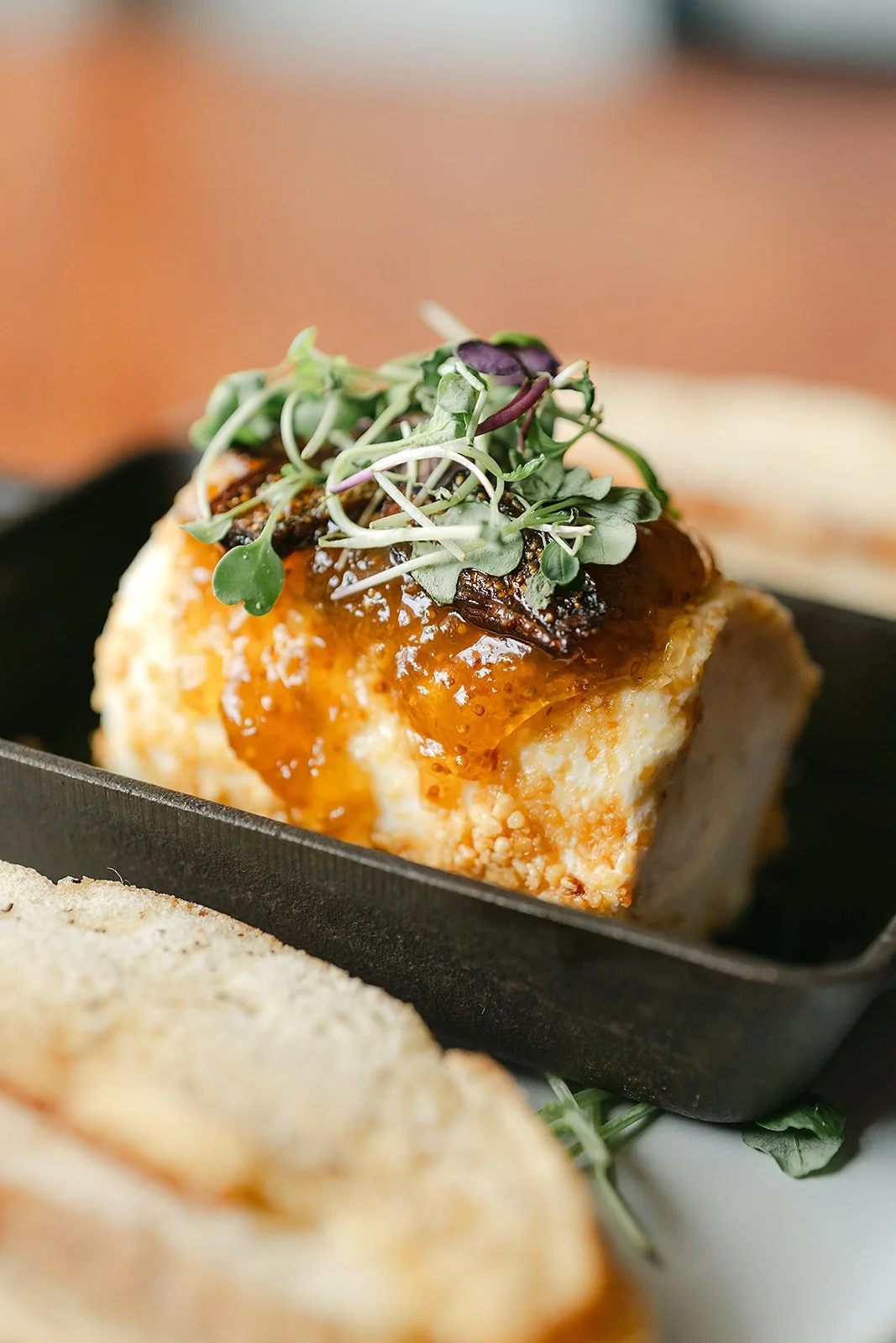 Baked goat cheese in a cast iron pan.