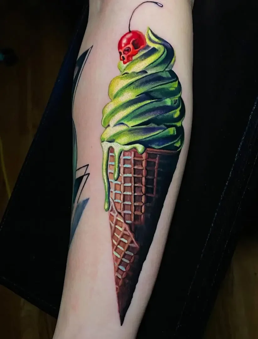 Tattoo of an ice cream cone with green ice cream, a red skull, and melting green sauce on top.
