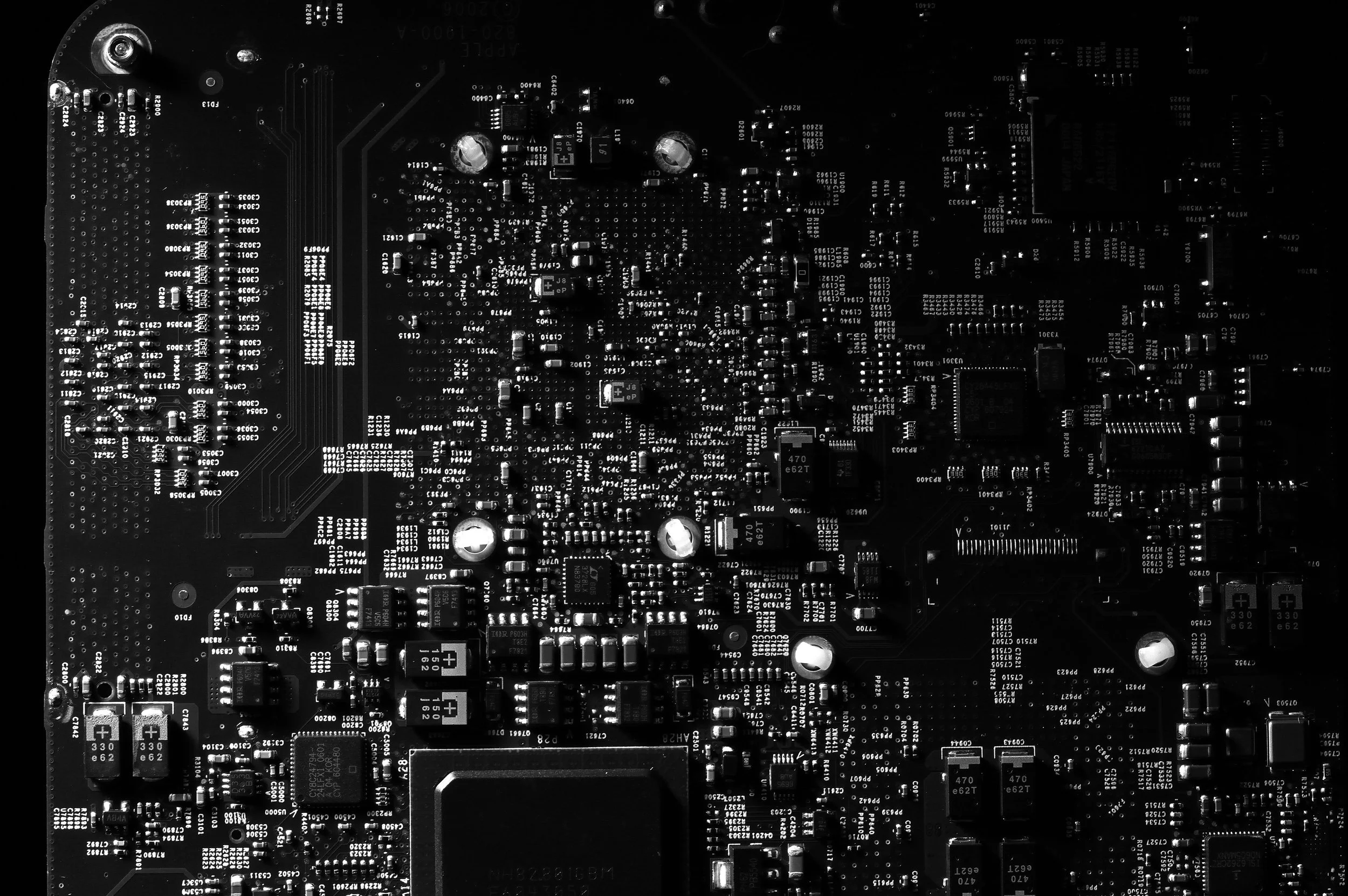 A black and white close-up photograph of a computer circuit board with various electronic components and chips.
