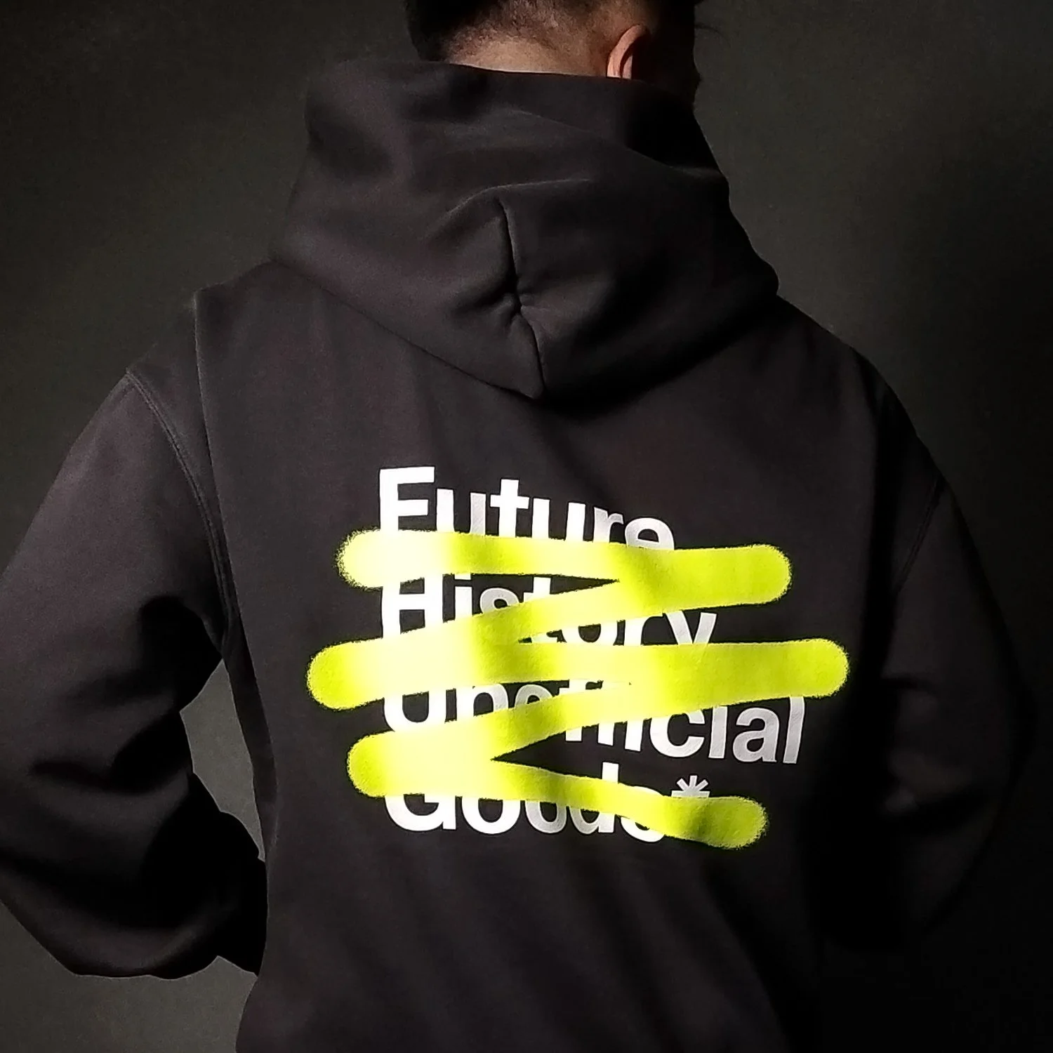 Back of a person wearing a black hoodie with the words 'Future, HiTech, Unethical, Good' printed in white. Five horizontal yellow highlighter strokes obscure parts of the text.