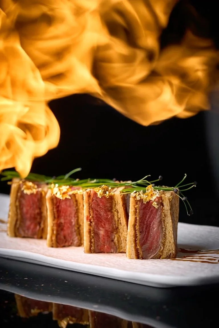 Slices of seared tuna steak with pink centers, garnished with microgreens