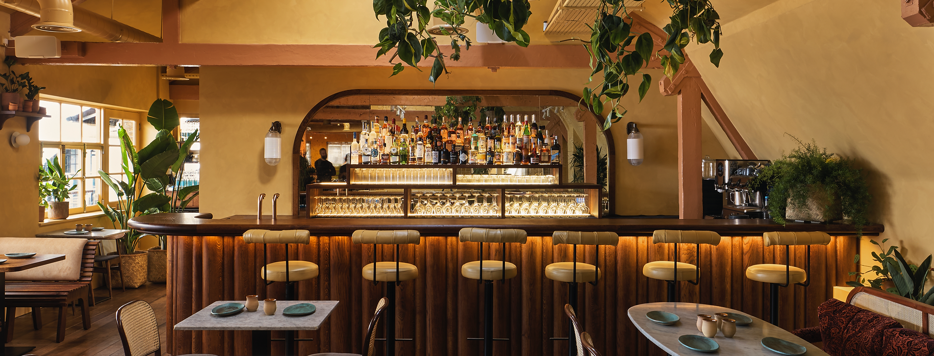 Interior of a cozy restaurant with a bar in the background