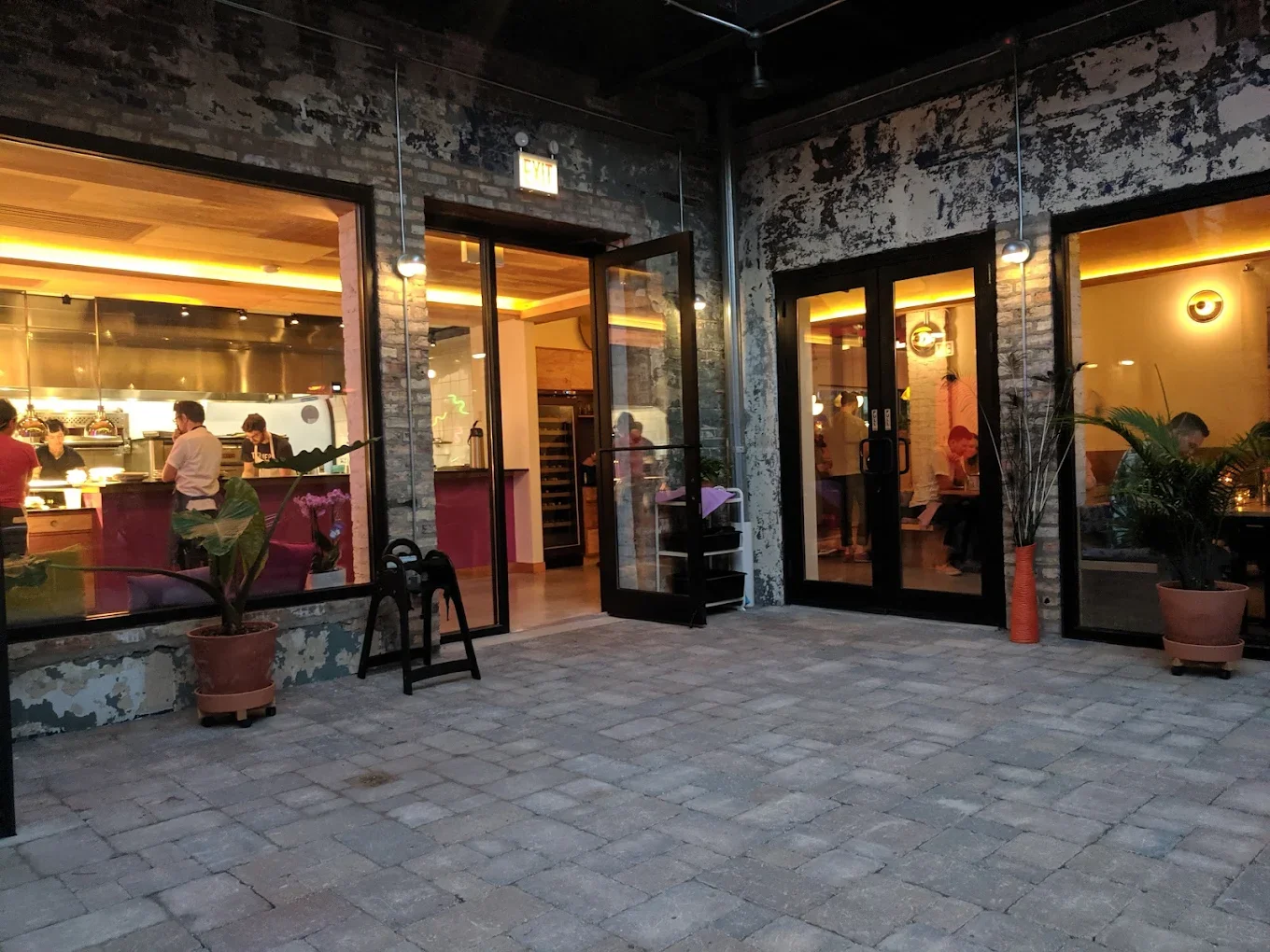 Exterior view of a modern brick restaurant with large glass windows and doors