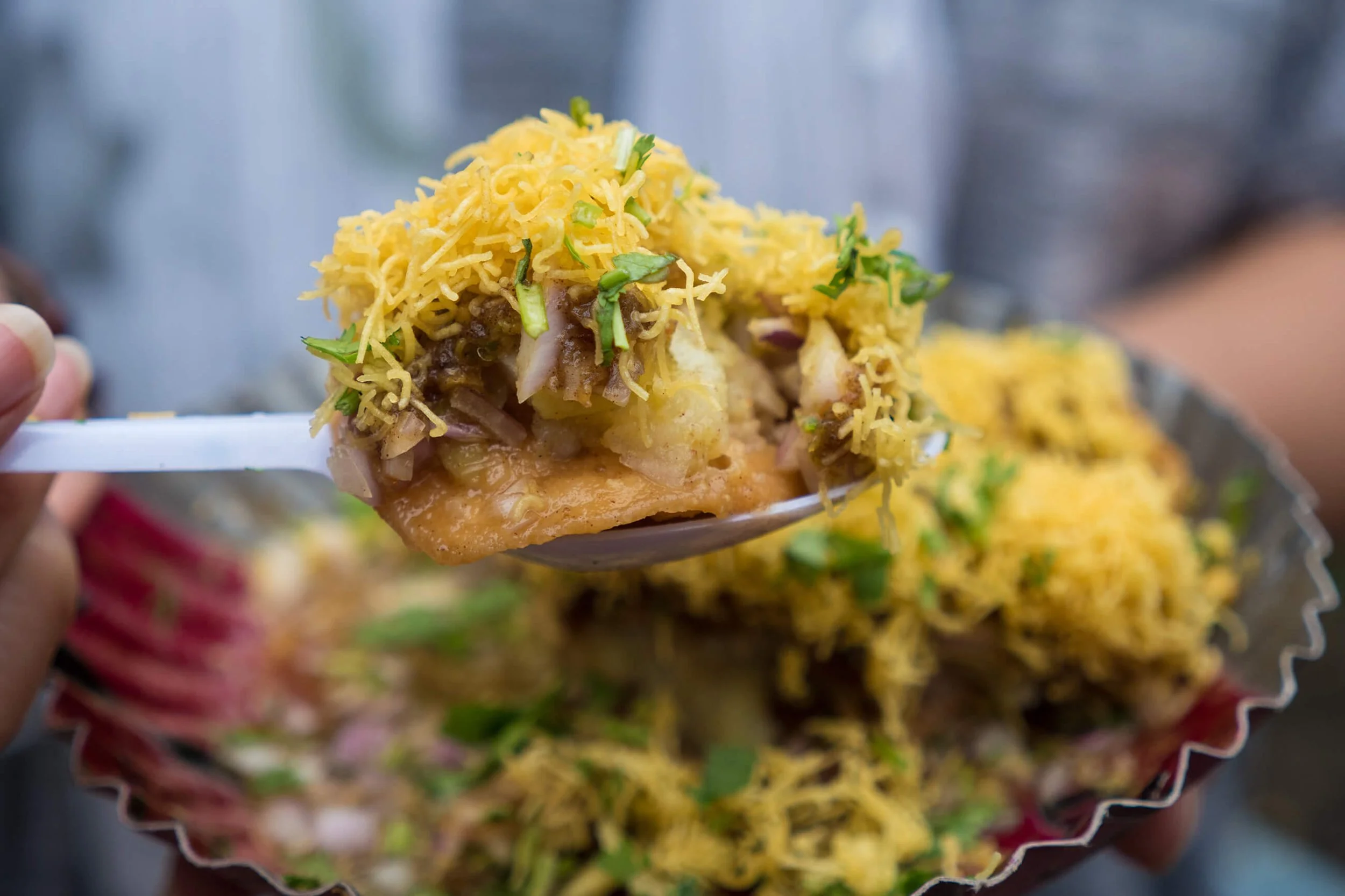 Close-up of a spoonful of food with shredded yellow cheese