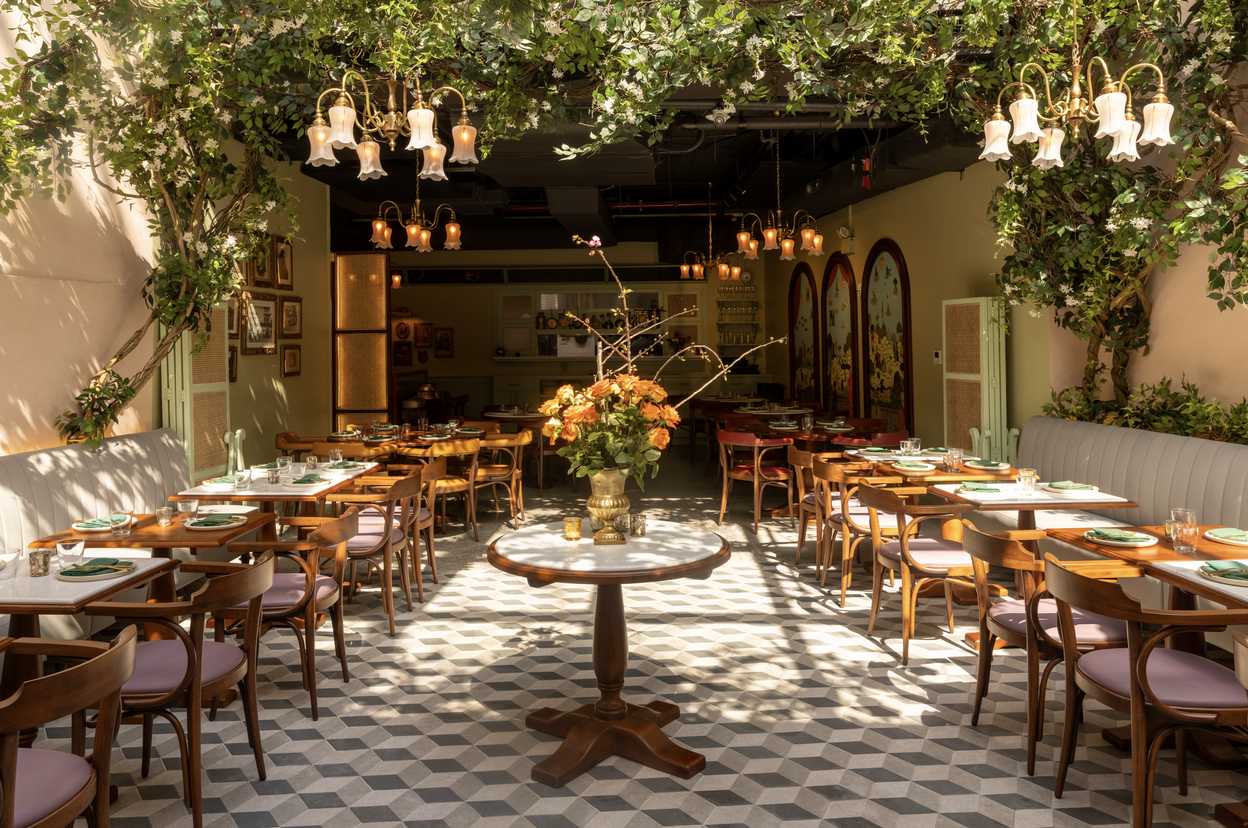 Elegant restaurant interior with large green vines and white flowers hanging from the ceiling.
