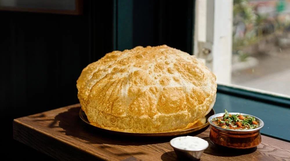 Large bowl of Indian bread, likely a naan or bread.