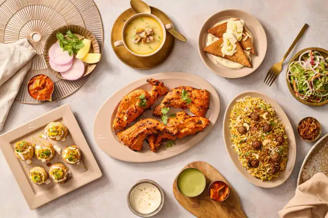 Assorted Indian dishes on a table including fried chicken