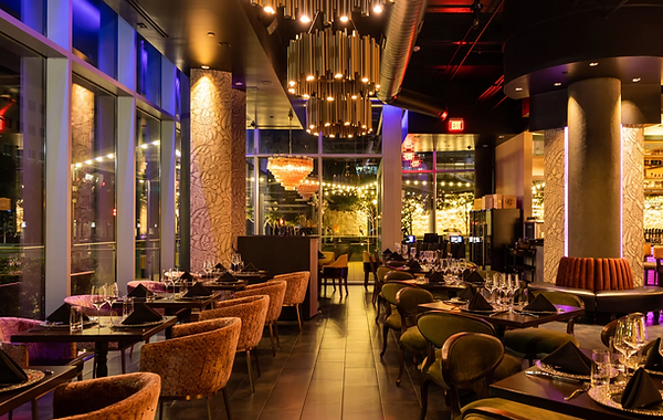 Interior of a modern restaurant with tables set for dining, and plush chairs