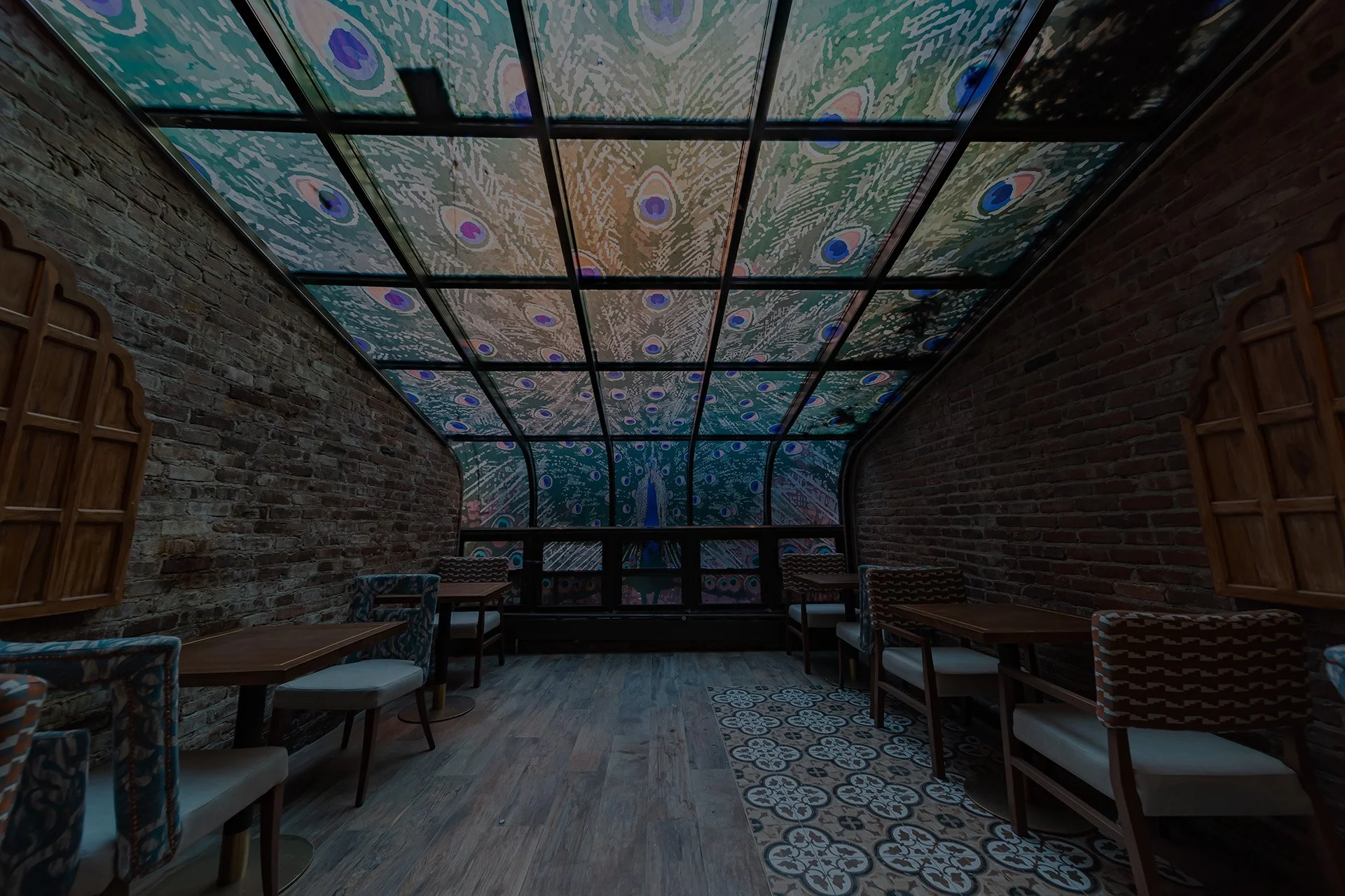 Indoor seating area with brick walls, and patterned chairs.