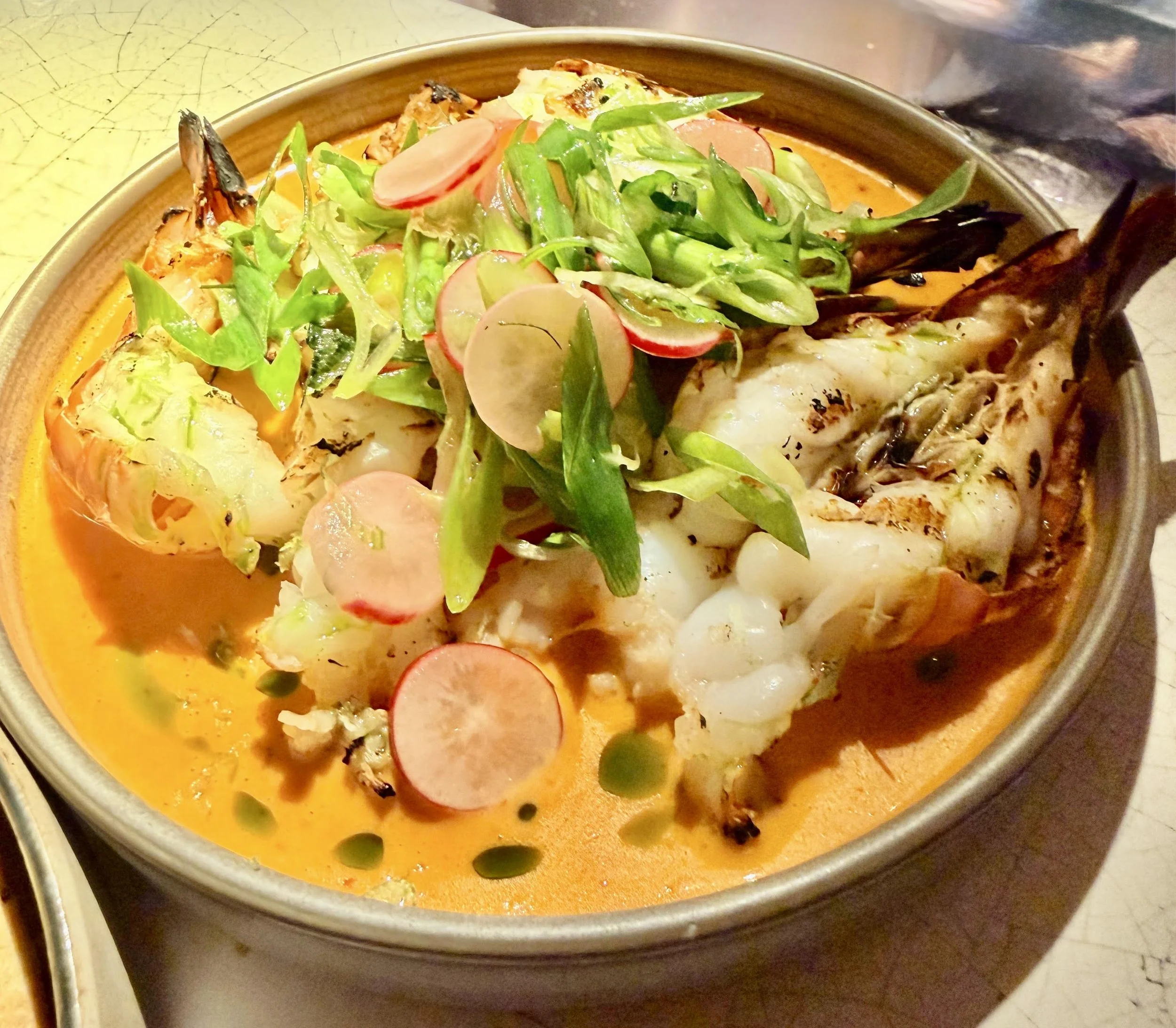 Grilled jumbo prawns in a decadent yellow sauce at Kricket, London.