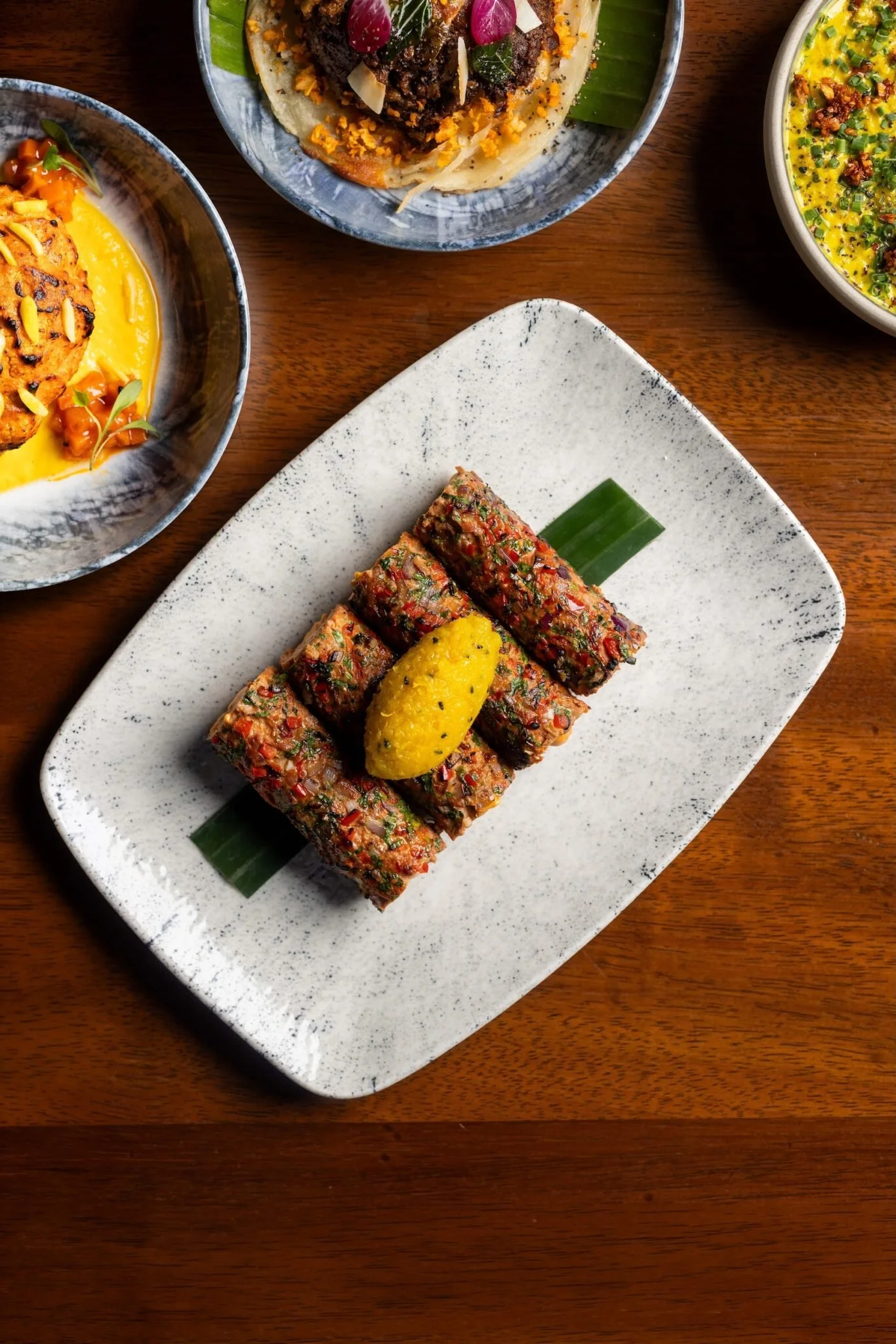 Close-up of a serving of raw, chopped meat seasoned with herbs and spices