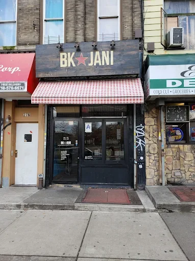 Storefront with a black sign that reads 'BK JANI' with a pink star in the middle.