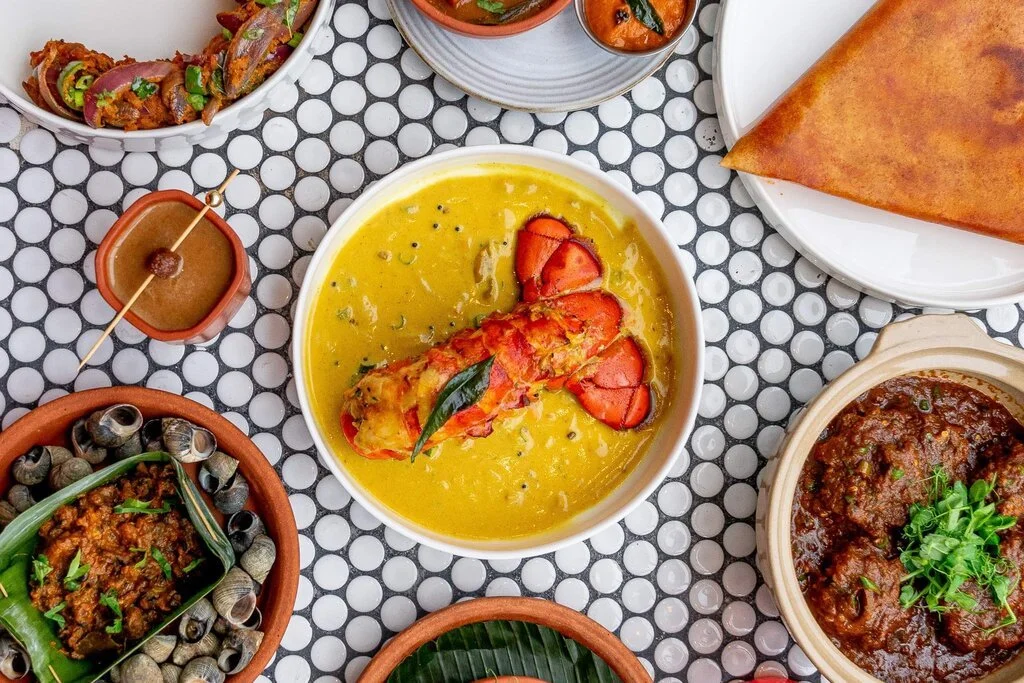 An array of Indian dishes on a table, including a lobster.