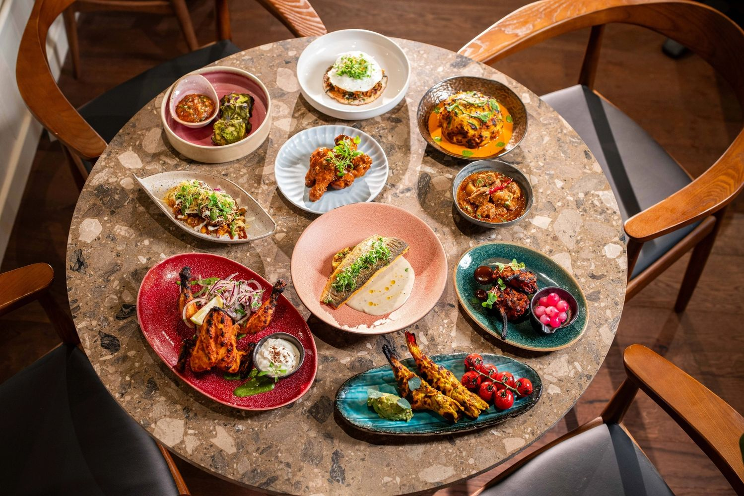 Various Indian dishes on a round table, including grilled chicken