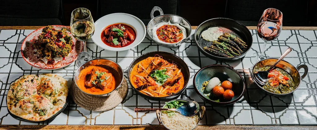 Assorted Indian dishes, including naan bread, curries, rice, and vegetables.