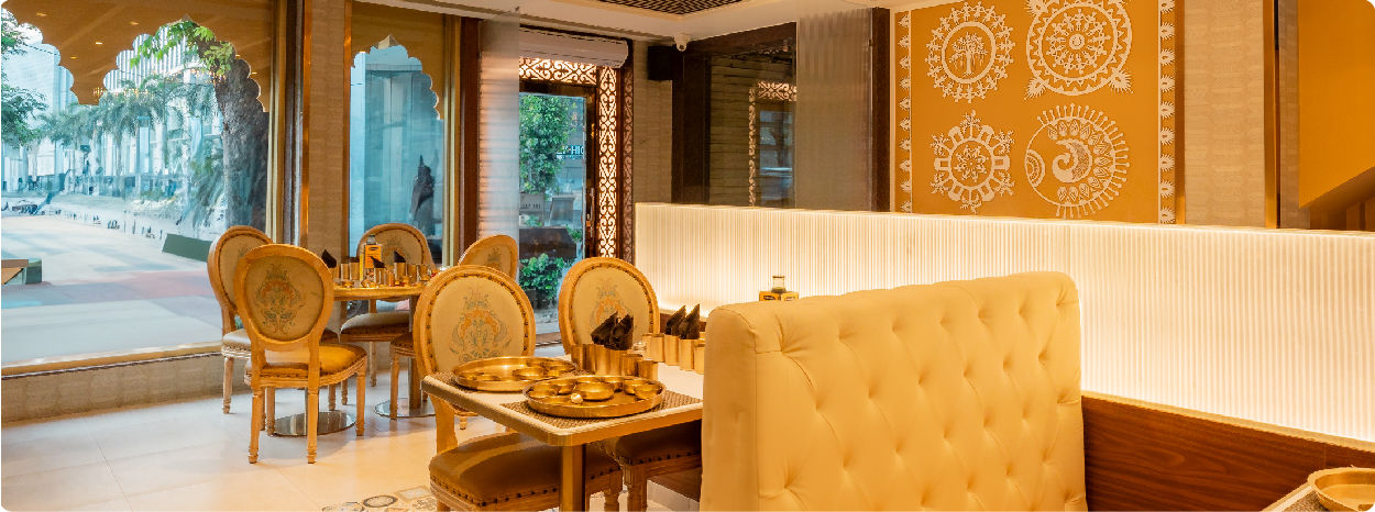 Elegant restaurant interior with vintage-style chairs, and a tufted cream-colored booth