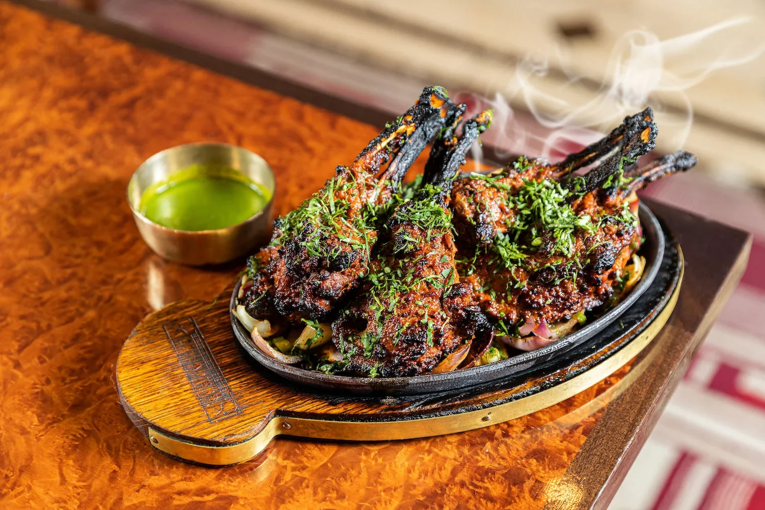 A sizzling plate of grilled lamb chops topped with fresh herbs