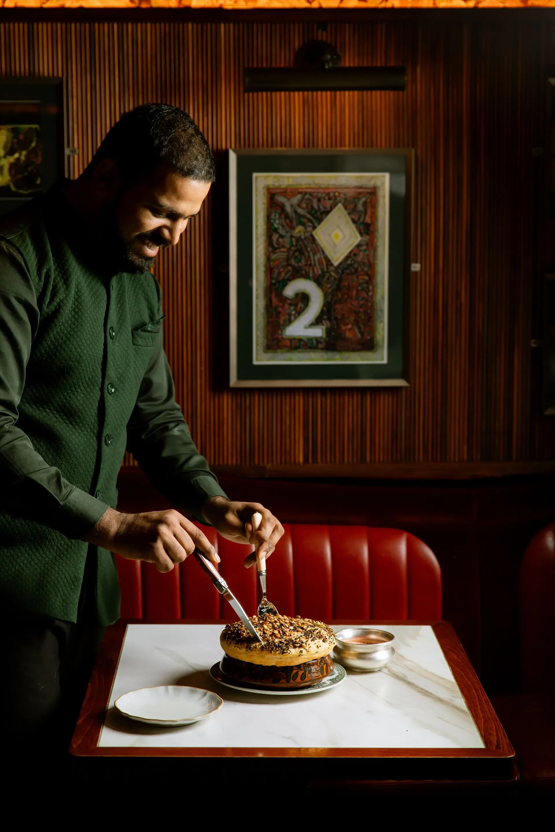 best south asian restaurants in london - a man slicing a cake