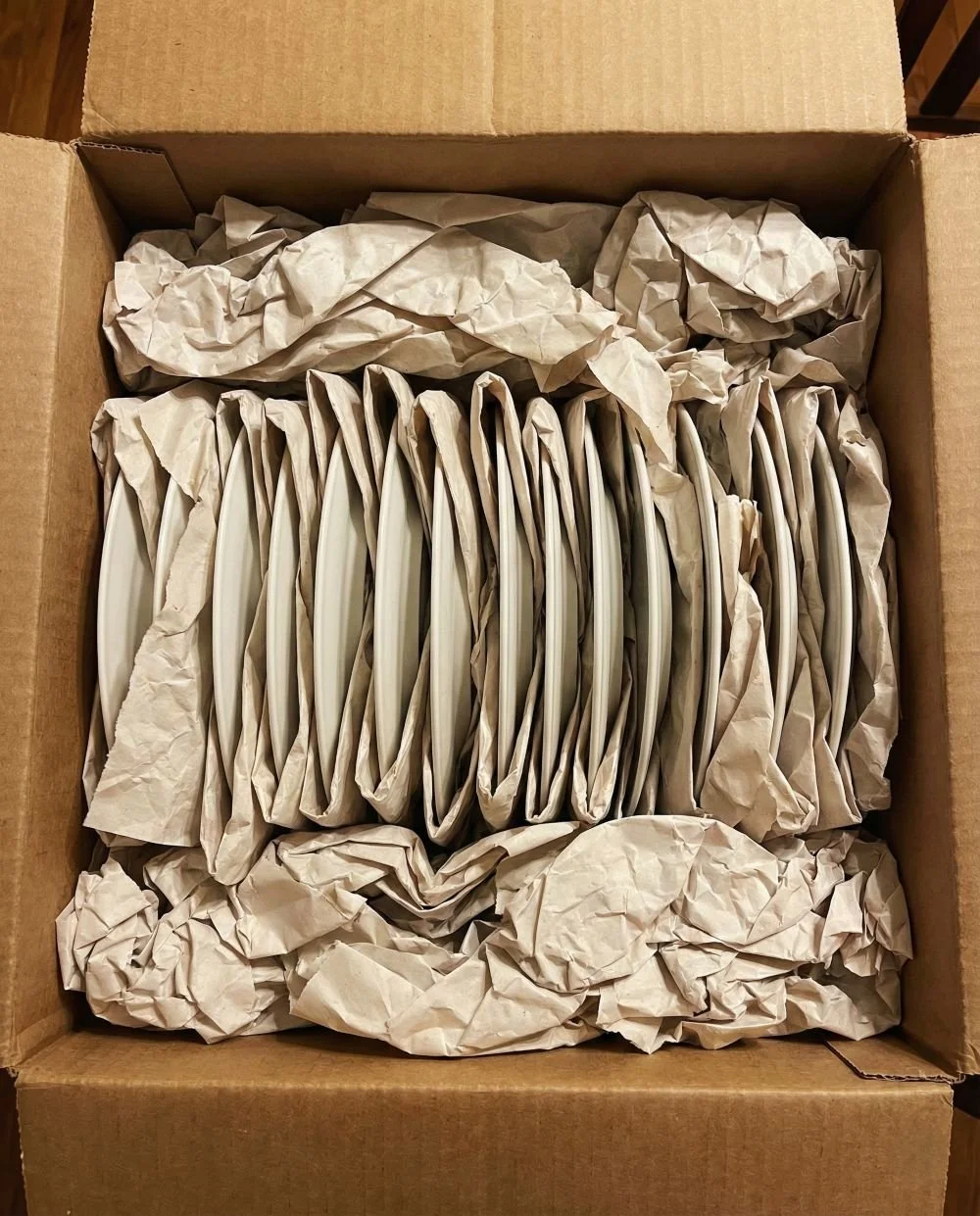 Inside view of a professionally packed dish barrel with plates stacked vertically for safety.